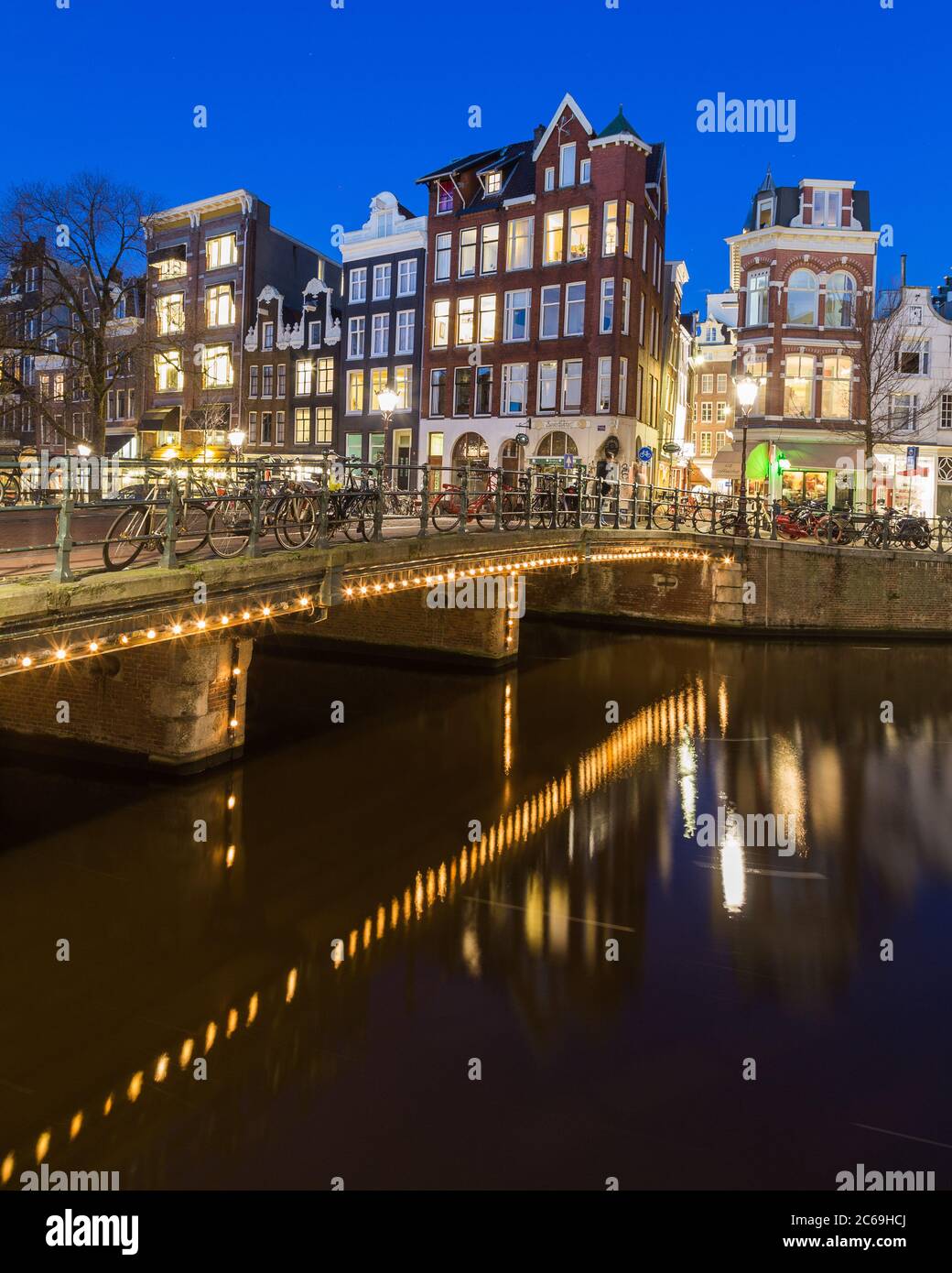 AMSTERDAM, PAESI BASSI - 16 FEBBRAIO 2016: Vista notturna lungo il canale Keizersgracht di Amsterdam. Edifici, ponti e biciclette possono essere visti. Foto Stock