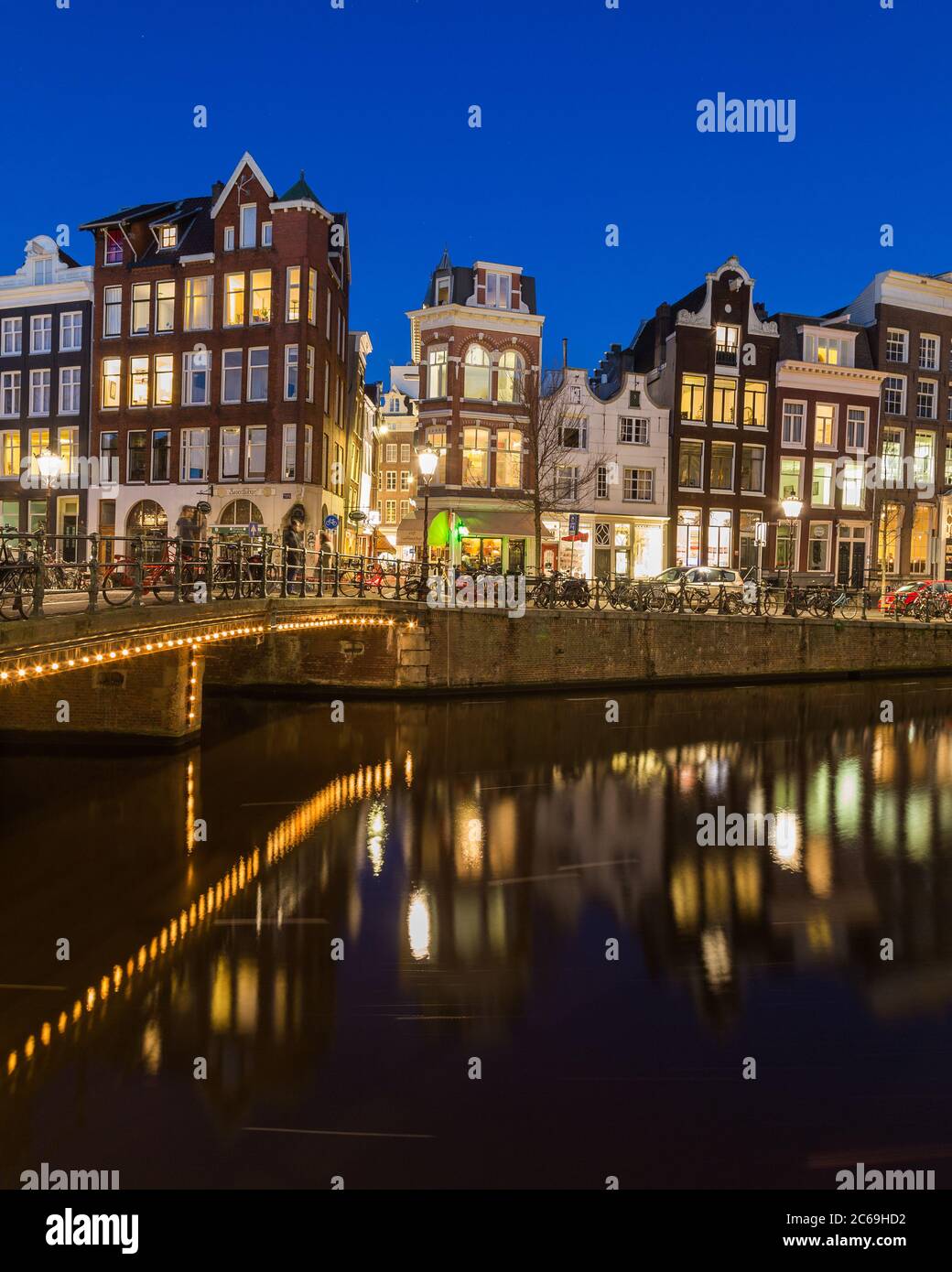AMSTERDAM, PAESI BASSI - 16 FEBBRAIO 2016: Vista notturna lungo il canale Keizersgracht di Amsterdam. Edifici, ponti, auto e biciclette possono essere ammirati Foto Stock
