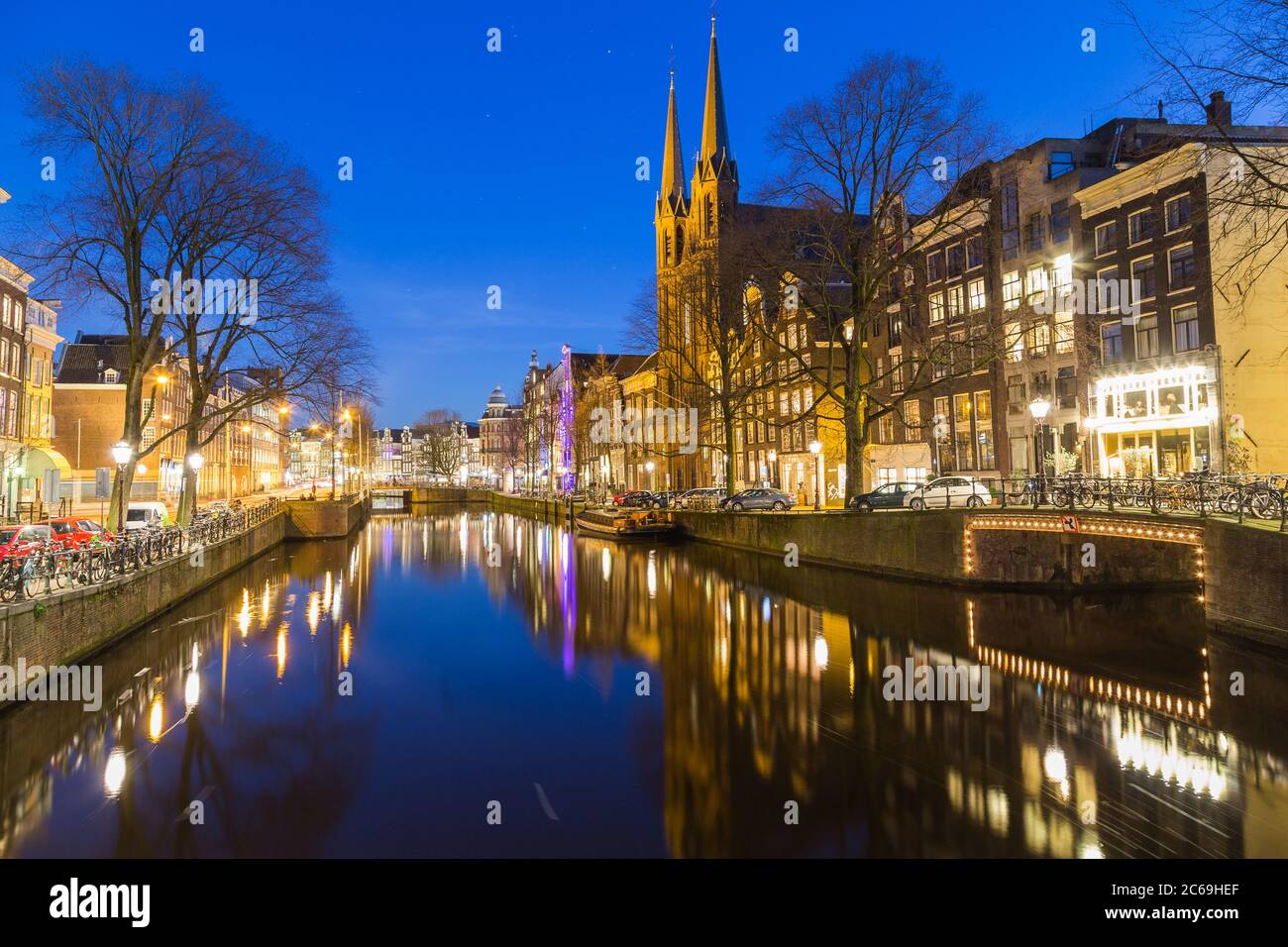 AMSTERDAM, PAESI BASSI - 16 FEBBRAIO 2016: Vista notturna lungo il canale Keizersgracht di Amsterdam. Riflessi, edifici, biciclette e automobili possono essere Foto Stock