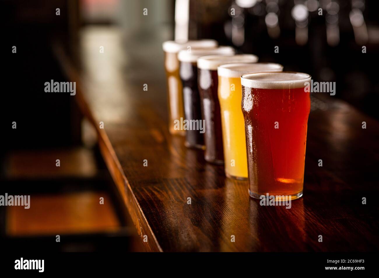 Oktoberfest. Birra lager, ale, chiara, scura e non filtrata in bicchieri sul banco bar in legno del pub Foto Stock