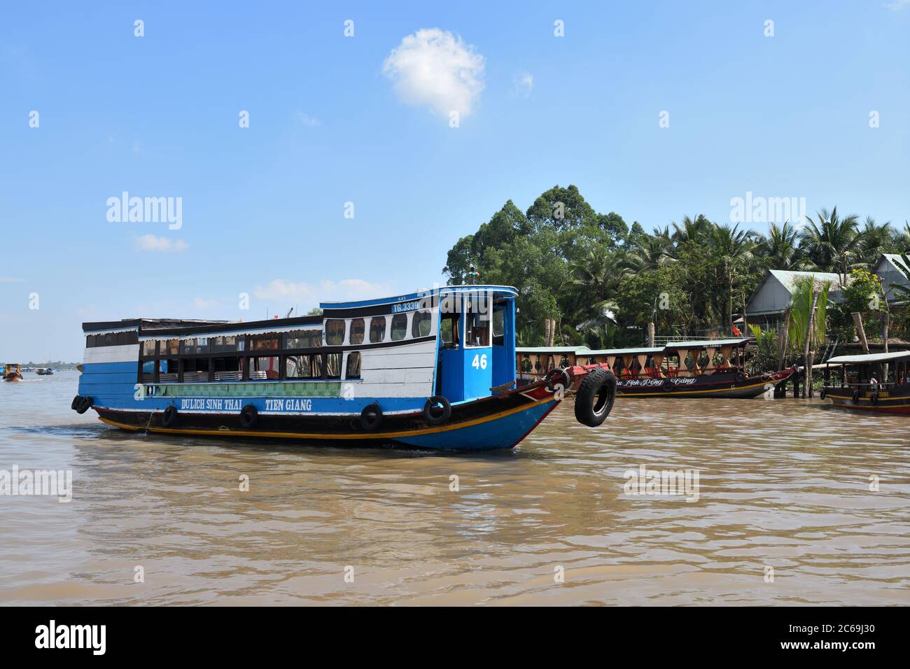 Barche a motore spazzatura che ferry passeggeri e visitatori sul massiccio silt fiume Mekong delta da My Tho in Vietnam, Asia Foto Stock