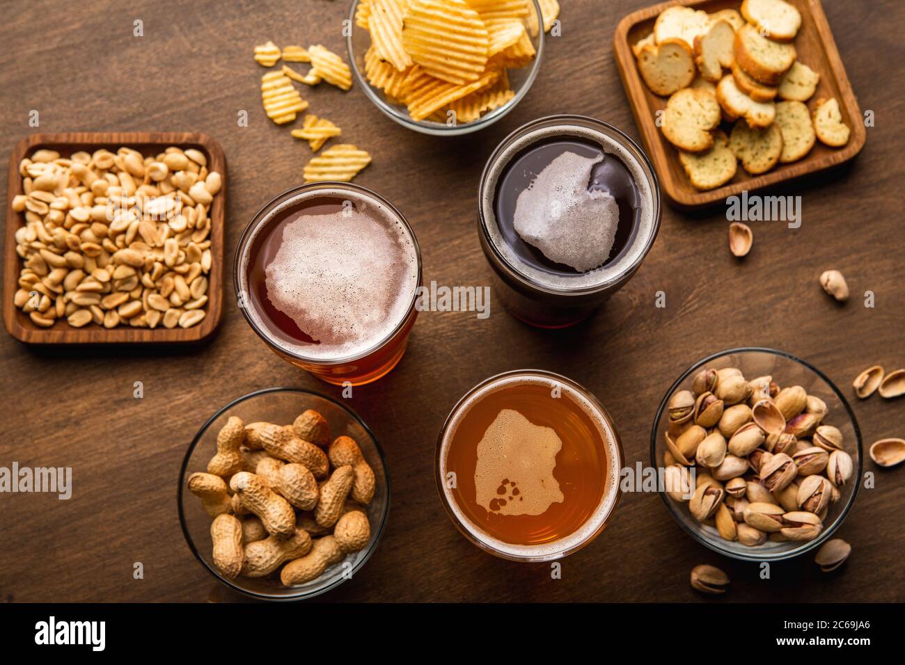 Pinta di birra per gli amici. Bevande artigianali in bicchieri e spuntini sul tavolo Foto Stock