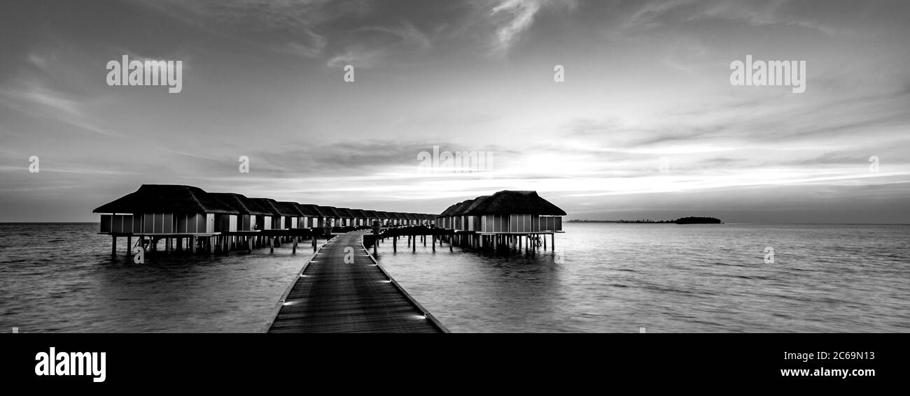 Idilliaco o spettacolare bungalow sull'acqua, Maldive Islands. Processo in bianco e nero per solitudine o ispirazione. Vista prospettica sul mare Foto Stock