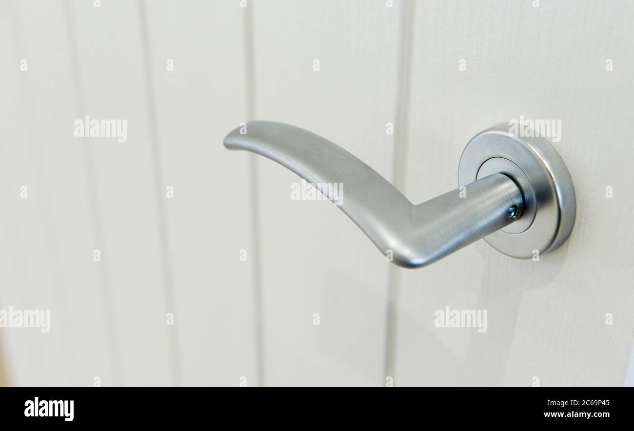 Primo piano di una maniglia metallica per porta a leva in una casa contemporanea. Foto Stock