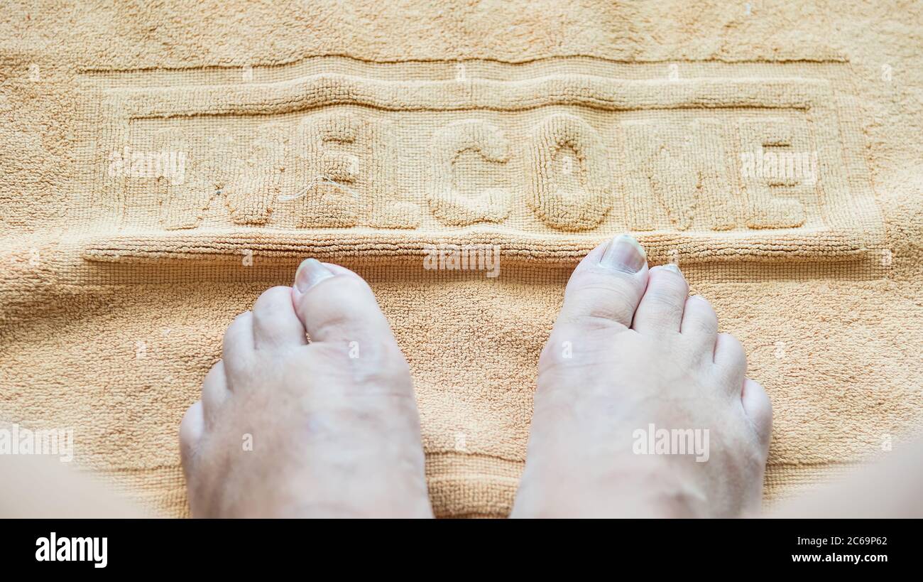 Asciugamano con cartello di benvenuto sul pavimento del bagno Foto Stock