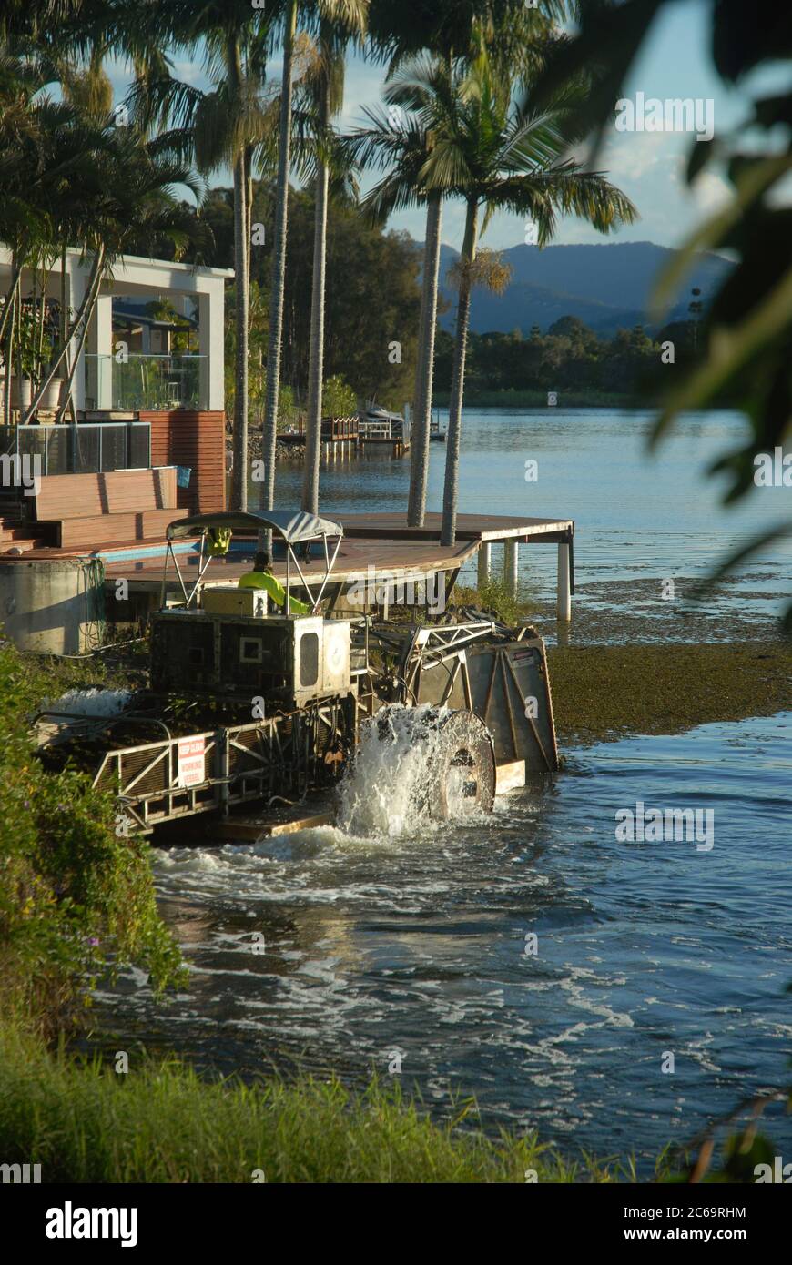 Barca sgomberare i canali, Clear Island Waters, Gold Coast, Queensland, Australia. Foto Stock