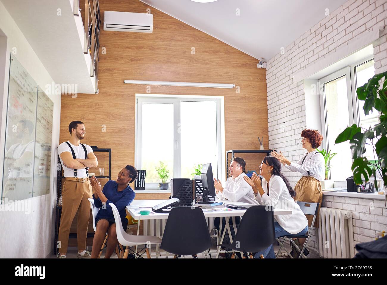 Pubblico multietnico, gruppo internazionale di ascoltatori applaudono a un buon pubblico parlare di giovane Foto Stock