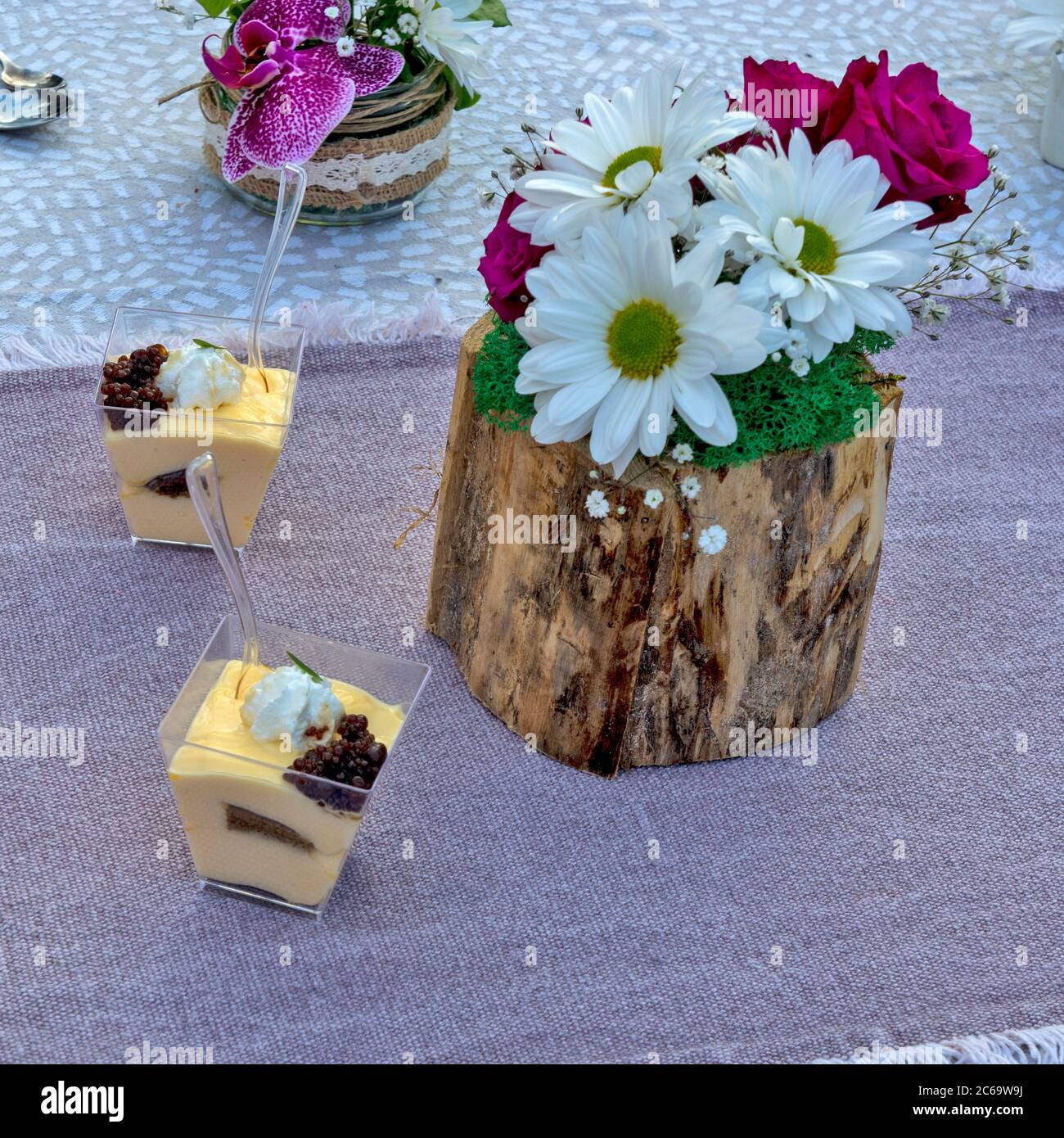 Fiori e budini messi sul tavolo come decorazione. Il budino è preparato per la degustazione e la valutazione, nonché per una disposizione floreale. Foto Stock