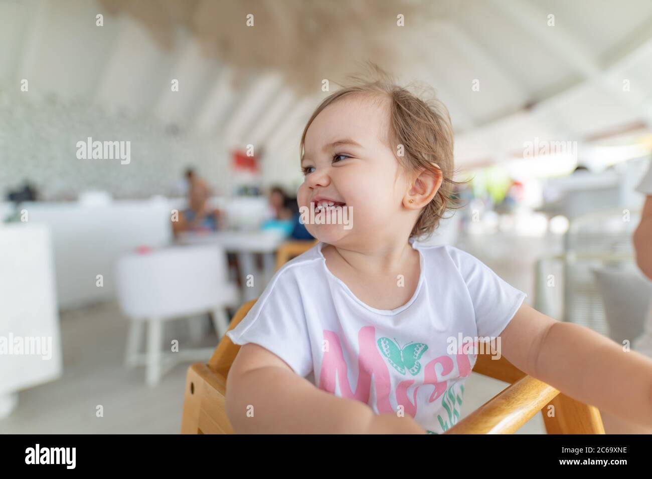 Adorabile bambina che mangia verdure sane e patate fritte malsane. Cute bambino felice che prende il cibo dal piatto all'asilo nido o asilo nido Foto Stock