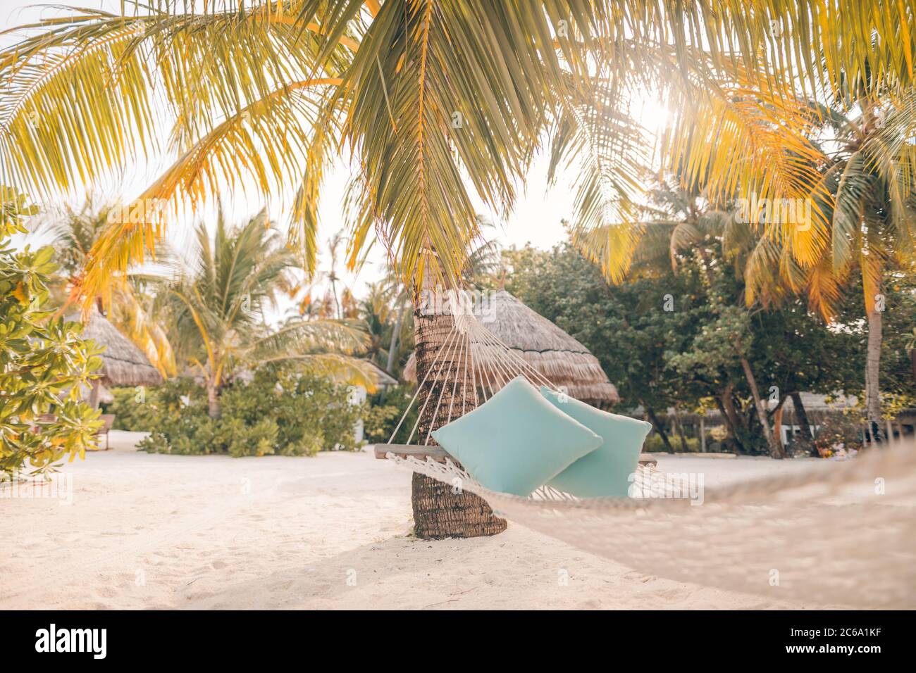 Vista panoramica del tramonto, amaca vuota appeso su palme da cocco su un'isola tropicale. Atmosfera estiva, umore, svago, relax Foto Stock