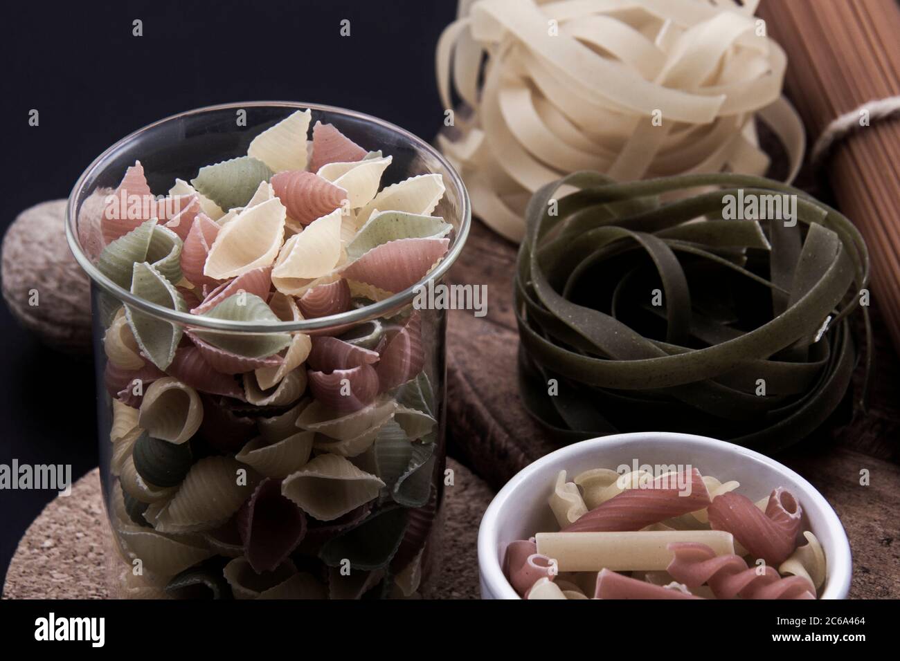 Pasta colorata e sagomata in diverse misure e colori in piccoli piatti insieme a un'ampia gamma. Foto Stock