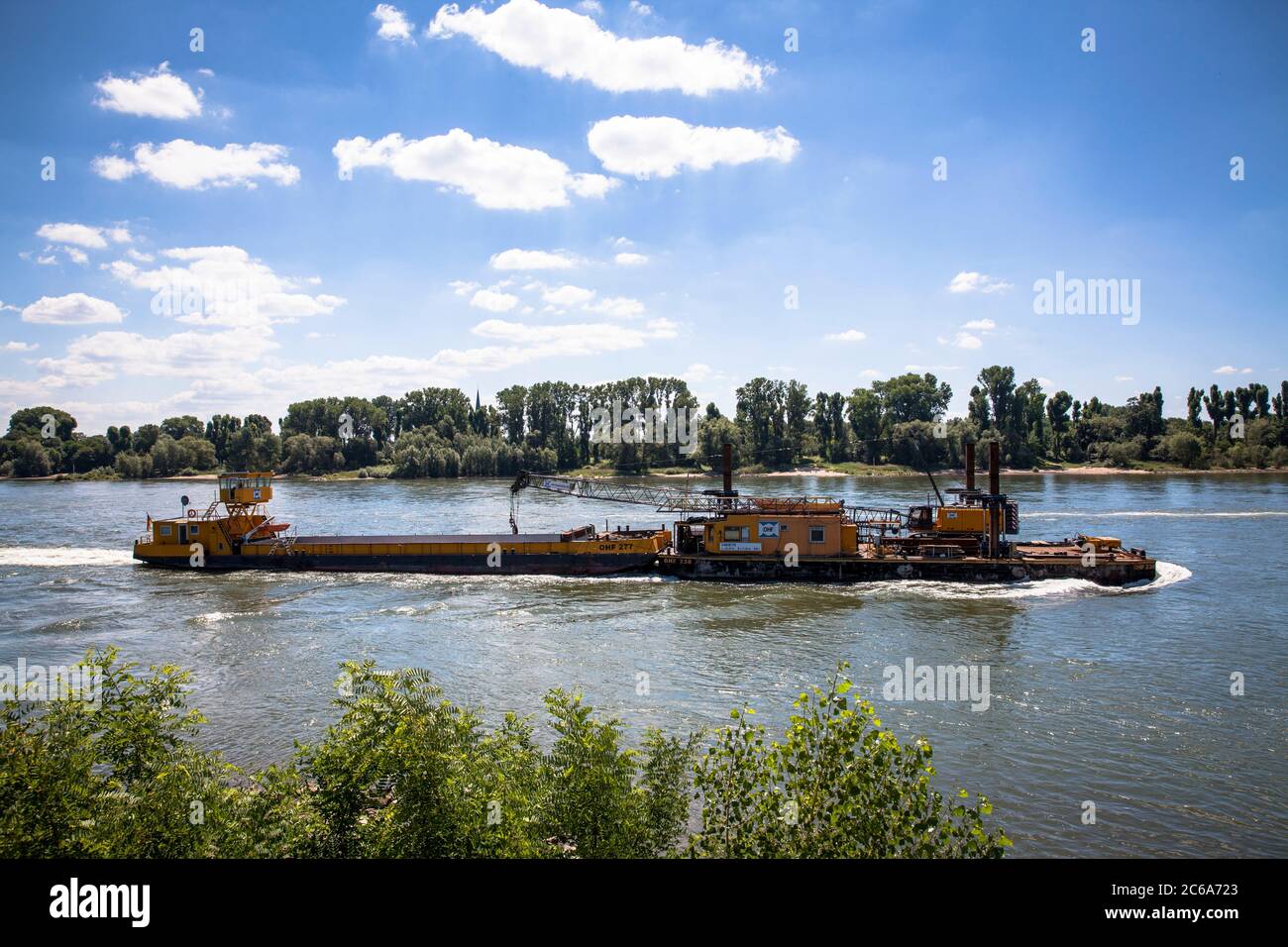 Una nave con un pontile idraulico su palafitte con una draga a cavo della società di ingegneria idraulica OHF Wasserbau sul fiume Reno, Colonia, Germania Foto Stock