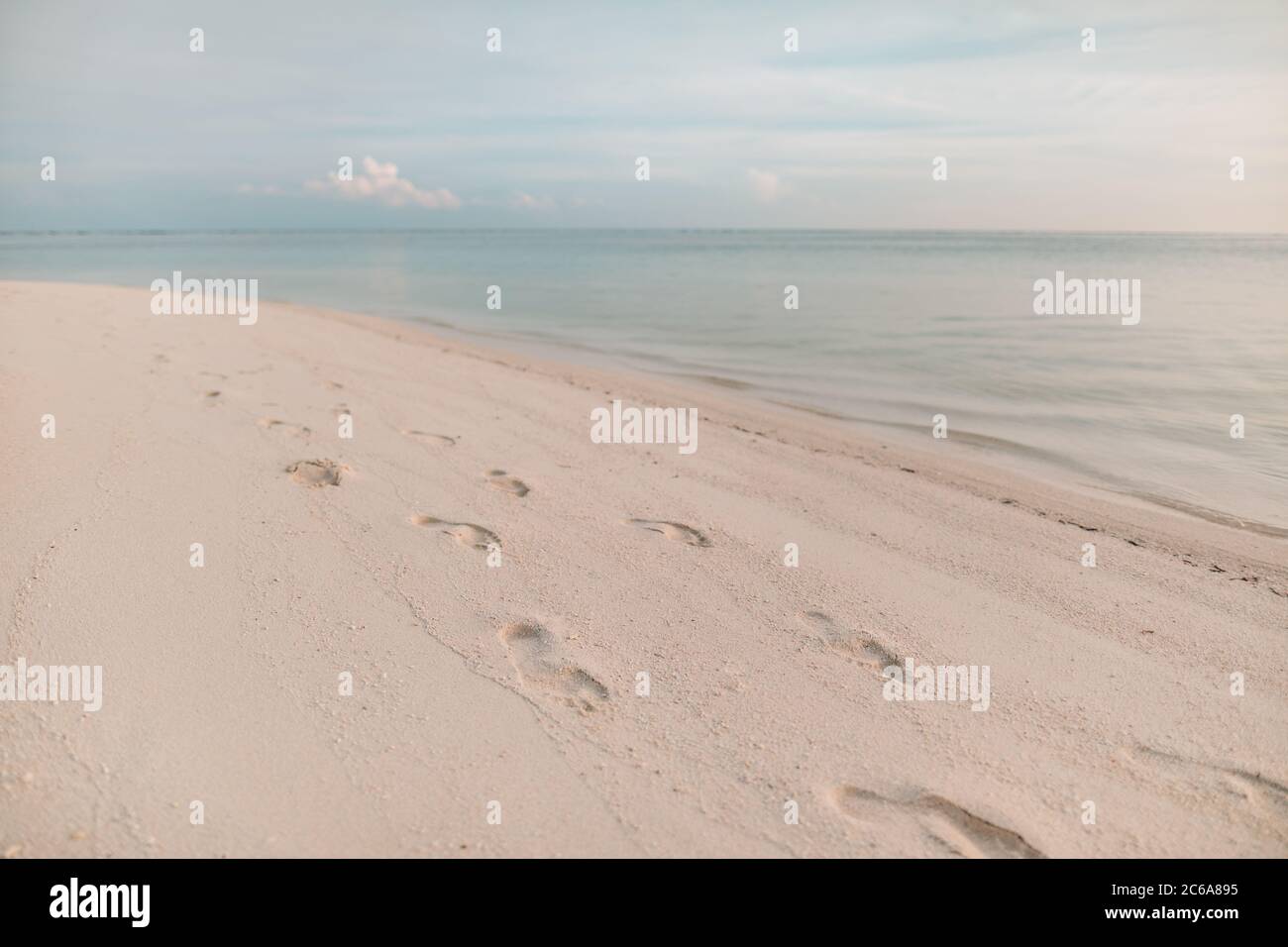 Spiaggia, onde e passi al tramonto. Rilassante paesaggio sulla spiaggia. Foto Stock