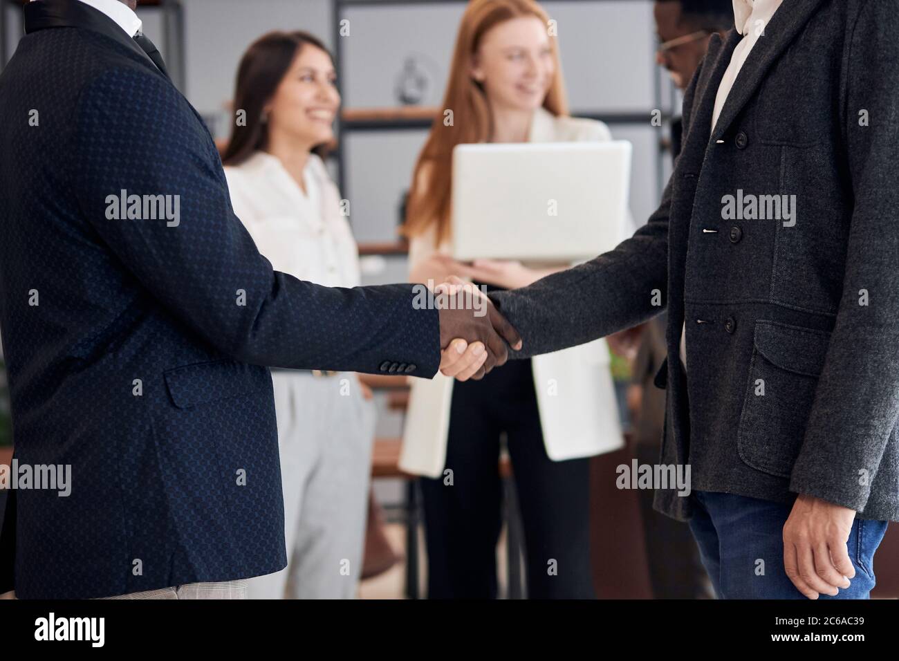 closeup afroamericano e caucasico dopo l'incontro di affari interracial scuotono le mani. Conclusione positiva e felice dei negoziati Foto Stock