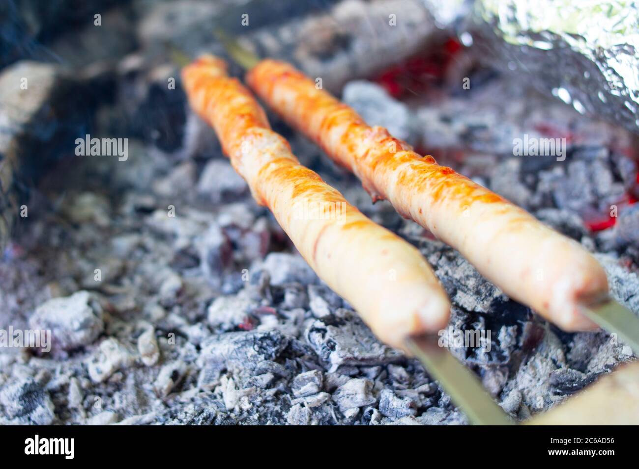le salsicce di carne vengono fritte su calici calde e cucinate all'aperto. Foto Stock