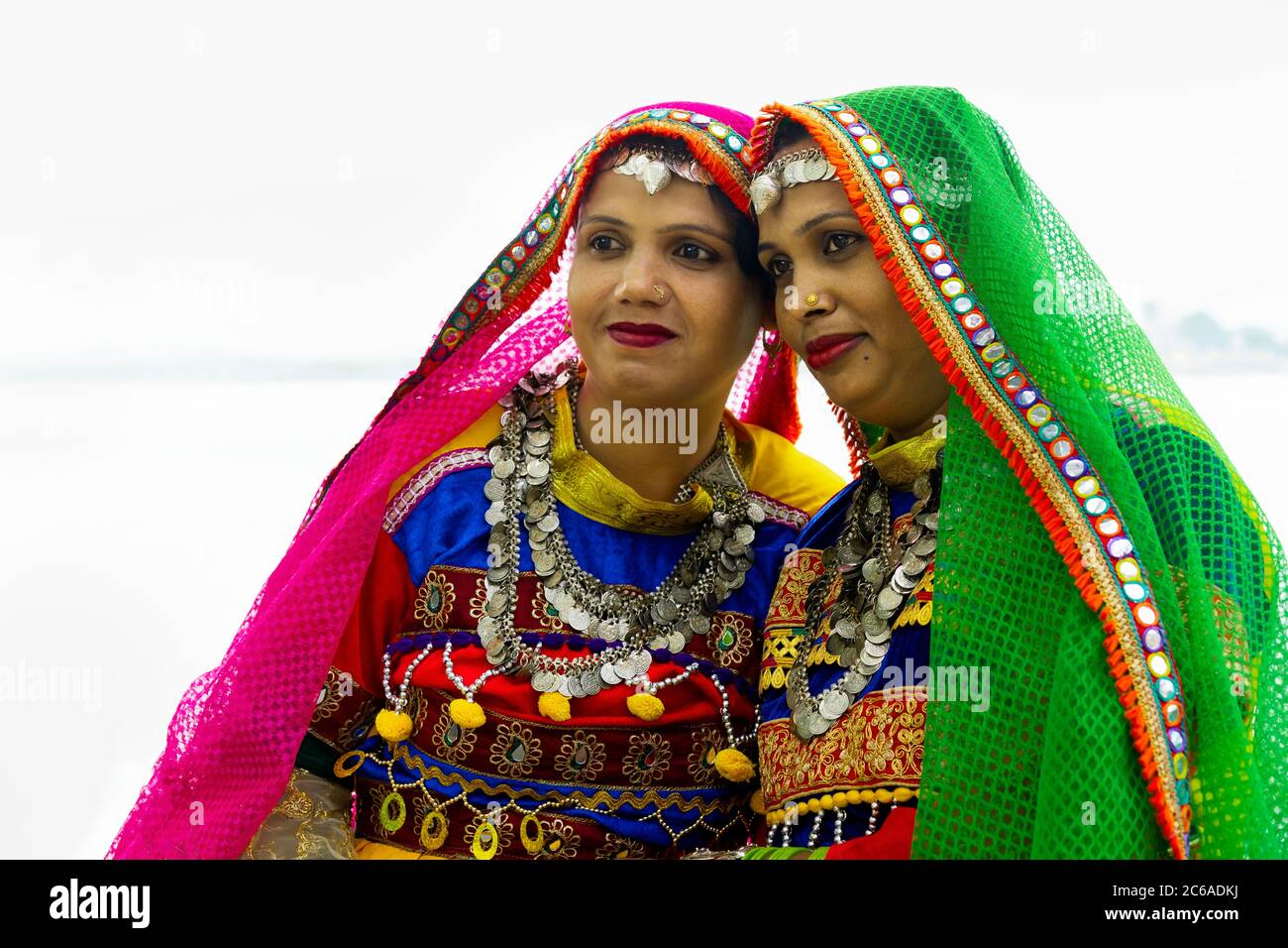 Due donne indiane vestite con abiti colorati e gioielli tradizionali a Udaipur, Rajasthan, India. Foto Stock