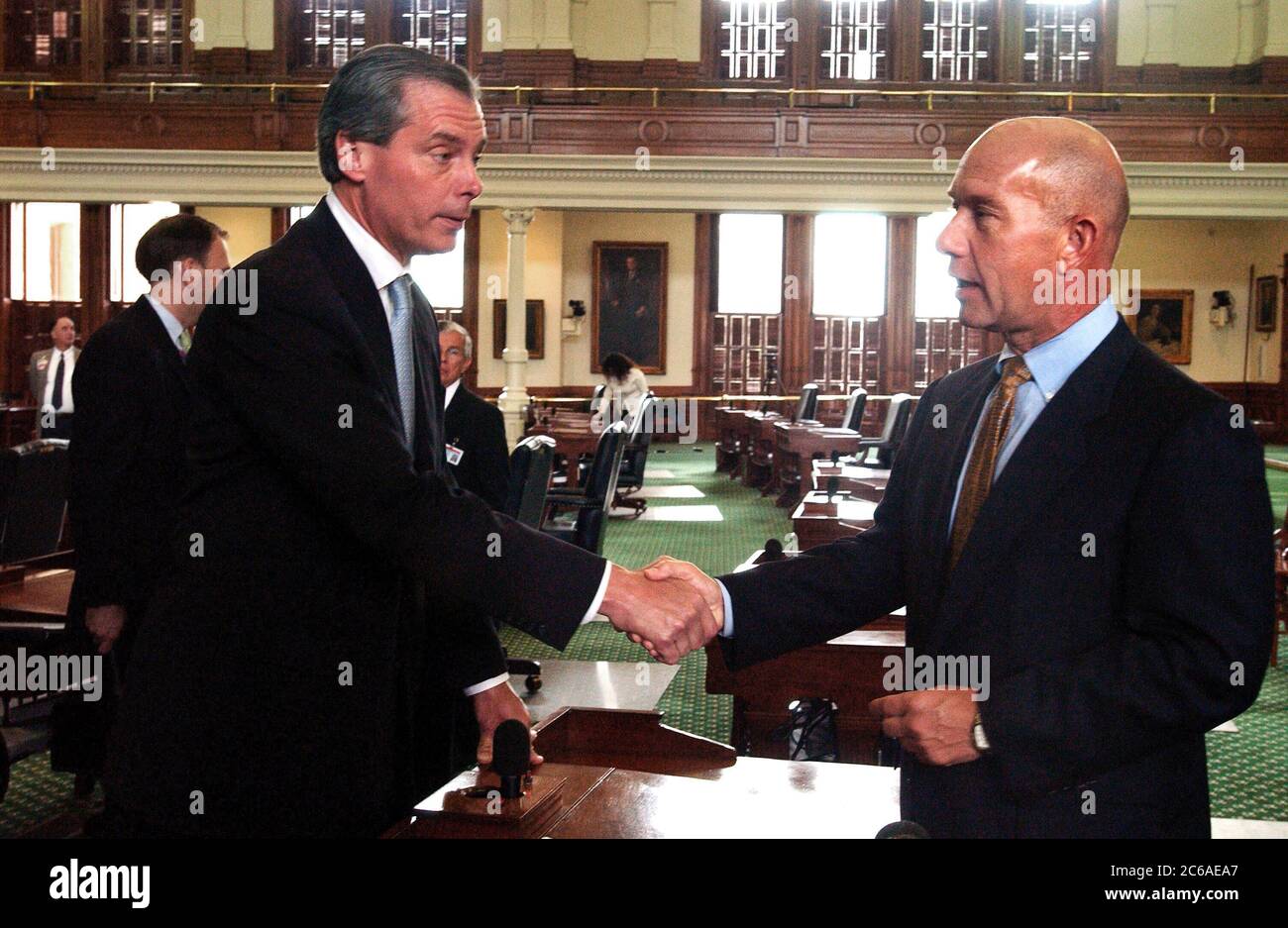 Austin, Texas USA, 16 settembre 2003: Il tenente governatore del Texas David Dewhurst (a sinistra) stringe la mano del senatore democratico John Whitmire di Houston mentre i senatori del Texas si incontrano al Campidoglio con saluti amichevoli, strette di mano e buona volontà per una terza sessione speciale. I Democratici sono tornati da un esilio autoimposto di sei settimane nel New Mexico per bloccare un disegno di legge riorganizzativo all'inizio di quest'estate. Entrambe le parti hanno promesso cooperazione per i prossimi 30 giorni. ©Bob Daemmrich Foto Stock