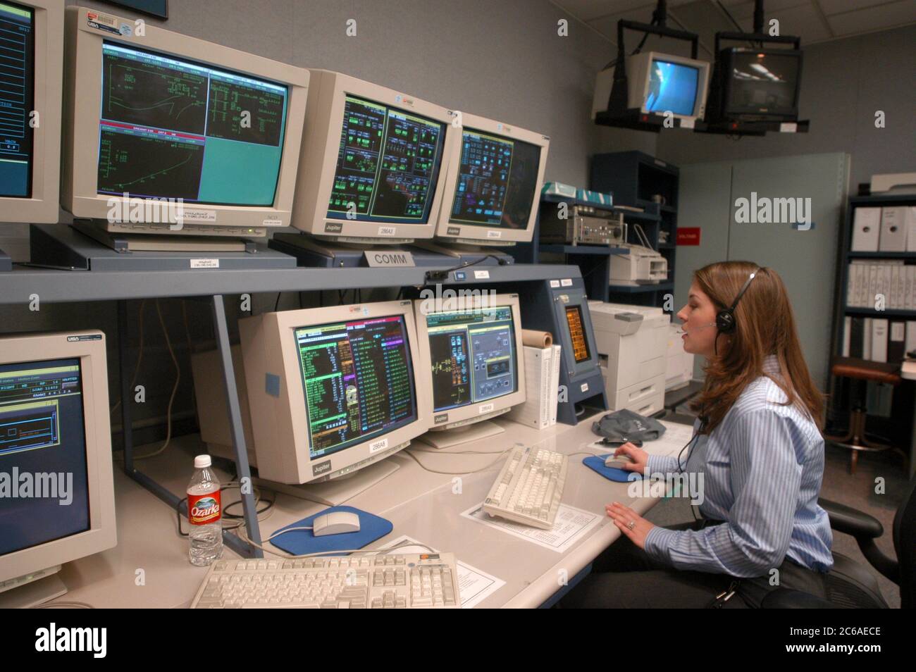 Houston Texas USA, 18 settembre 2003: Ingegnere informatico femminile che indossa cuffie lavora nella sala di controllo per il simulatore di salita/entrata basato sul movimento per lo Space Shuttle, dove gli addestratori mettono in atto scenari di missione per astronauti in addestramento. ©Bob Daemmrich Foto Stock