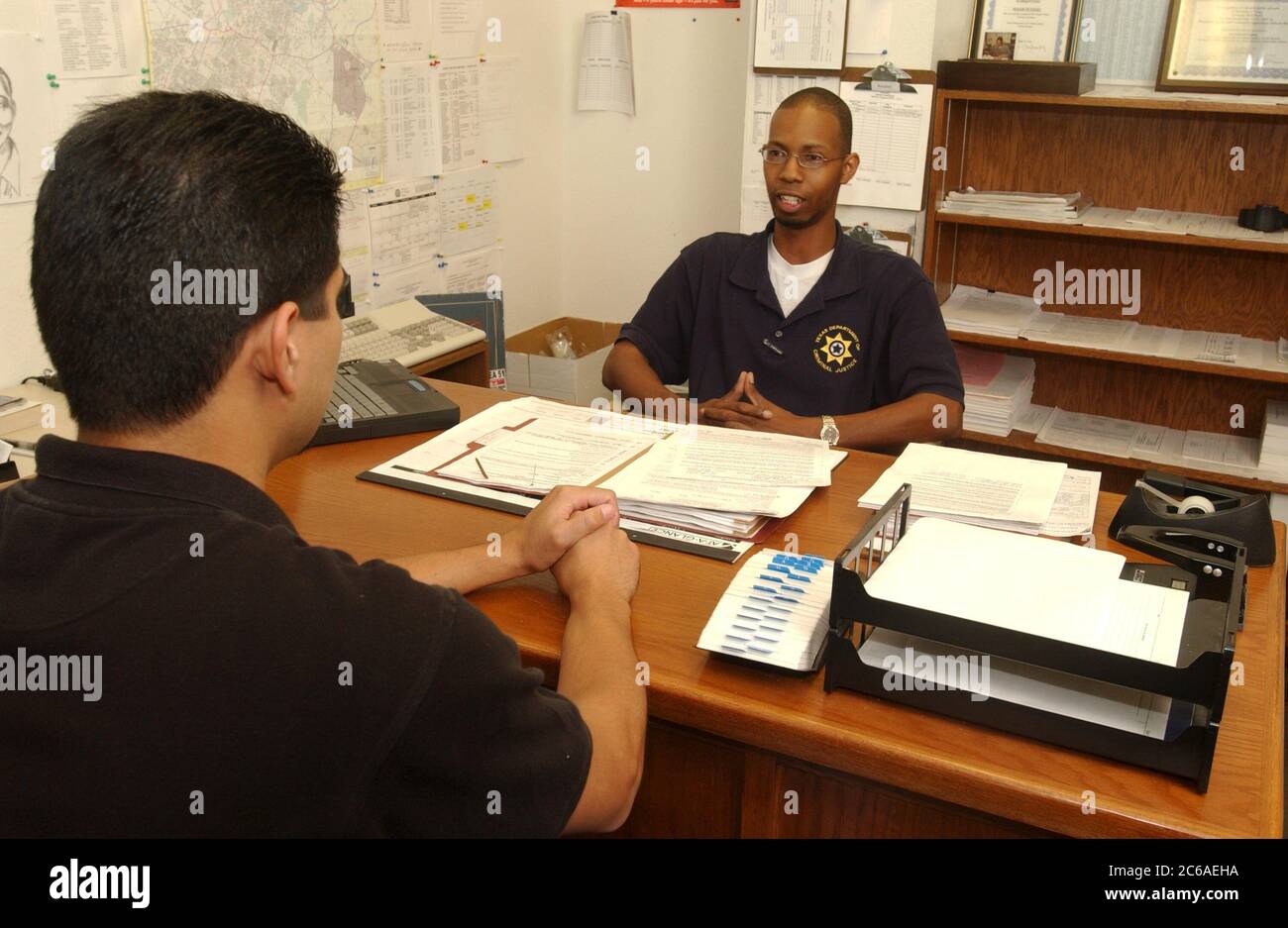 Austin Texas USA, 2003: Un ufficiale afro-americano di libertà vigilata incontra nel suo ufficio con un parolee ispanico per discutere di stare fuori dai guai mentre è in libertà vigilata. Modelli rilasciati ©Bob Daemmrich Foto Stock