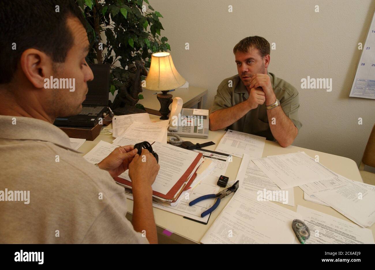 Austin Texas USA, 2003: Parolee (a destra) incontra il suo agente di libertà vigilata per discutere il monitoraggio elettronico. Modello rilasciato Hispanic ufficiale polo SP53, SP54. ©Bob Daemmrich Foto Stock