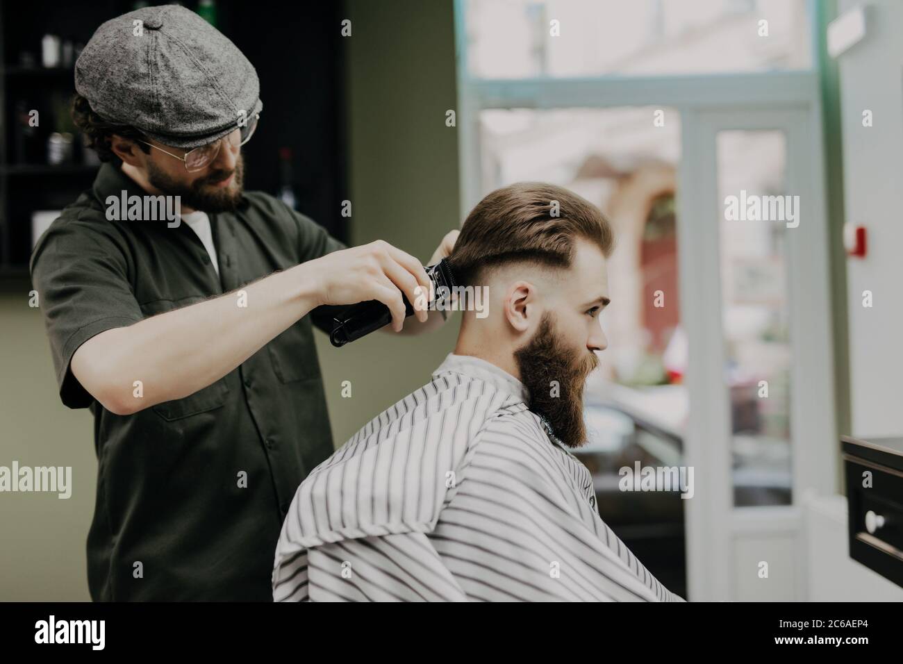 Acconciatura e taglio di capelli da uomo con macchina da barba da barbiere  taglio di capelli per uomo servizio di parrucchiere con rasoio in un  moderno negozio di barbiere in un lampo