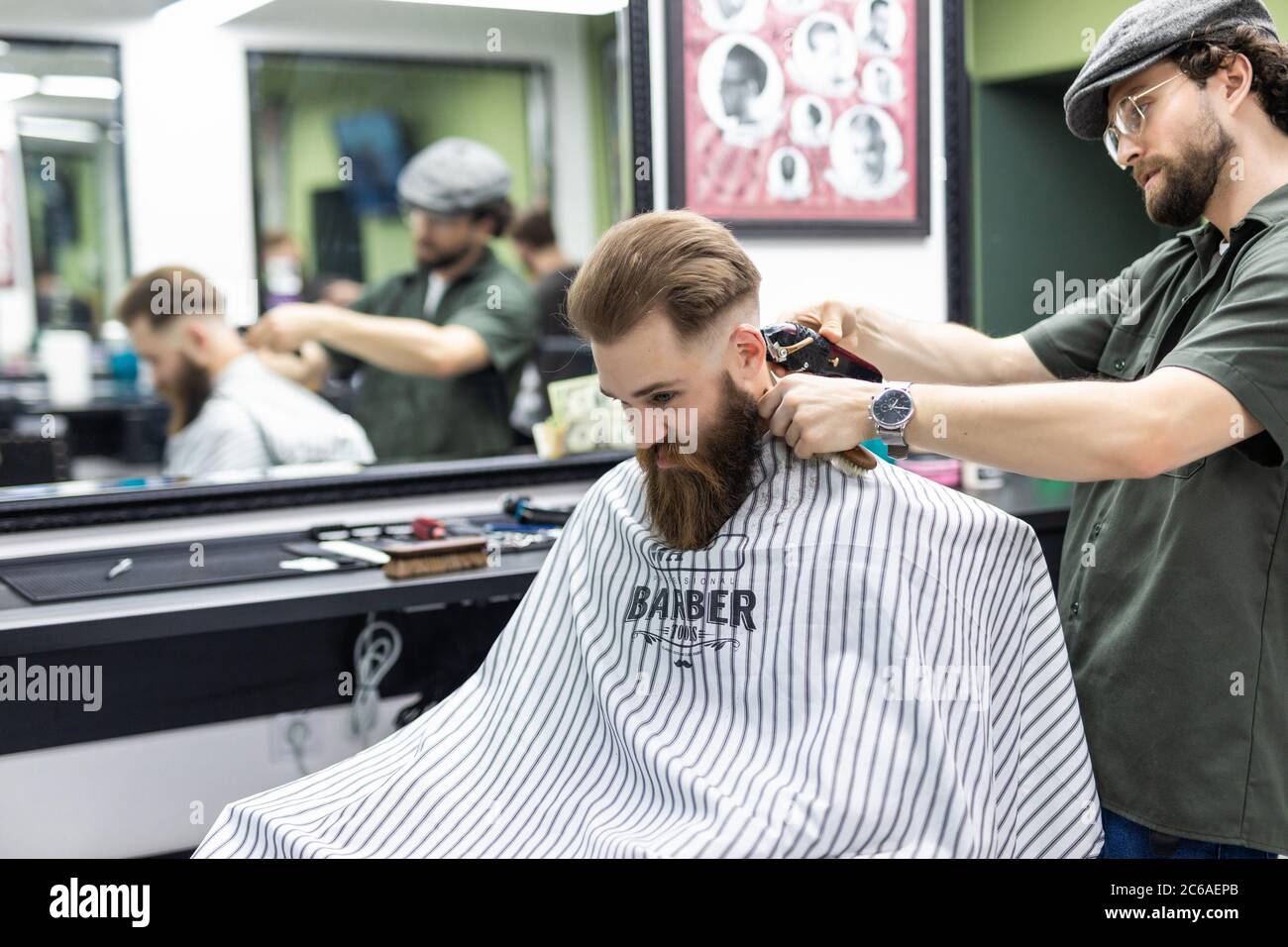 attraente barbiere che fa taglio di capelli di bell'uomo in barbiere,  accessori per capelli Foto stock - Alamy