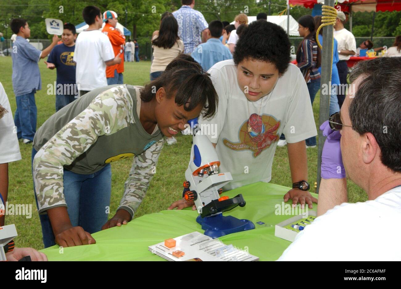 Austin Texas USA, aprile 2004: Gli studenti delle scuole medie di 6a e 7a elementare imparano a conoscere le questioni relative all'acqua e alle acque reflue all'evento scientifico all'aperto sponsorizzato dalla città di Austin. La ragazza nera guarda la materia organica attraverso il microscopio. ©Bob Daemmrich Foto Stock
