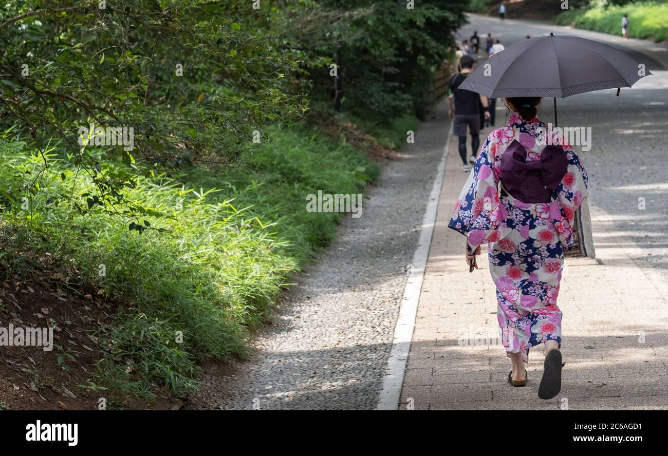 Donna che indossa kimono che cammina nel Santuario Meiji Jingu Shinto, Tokyo, Giappone Foto Stock