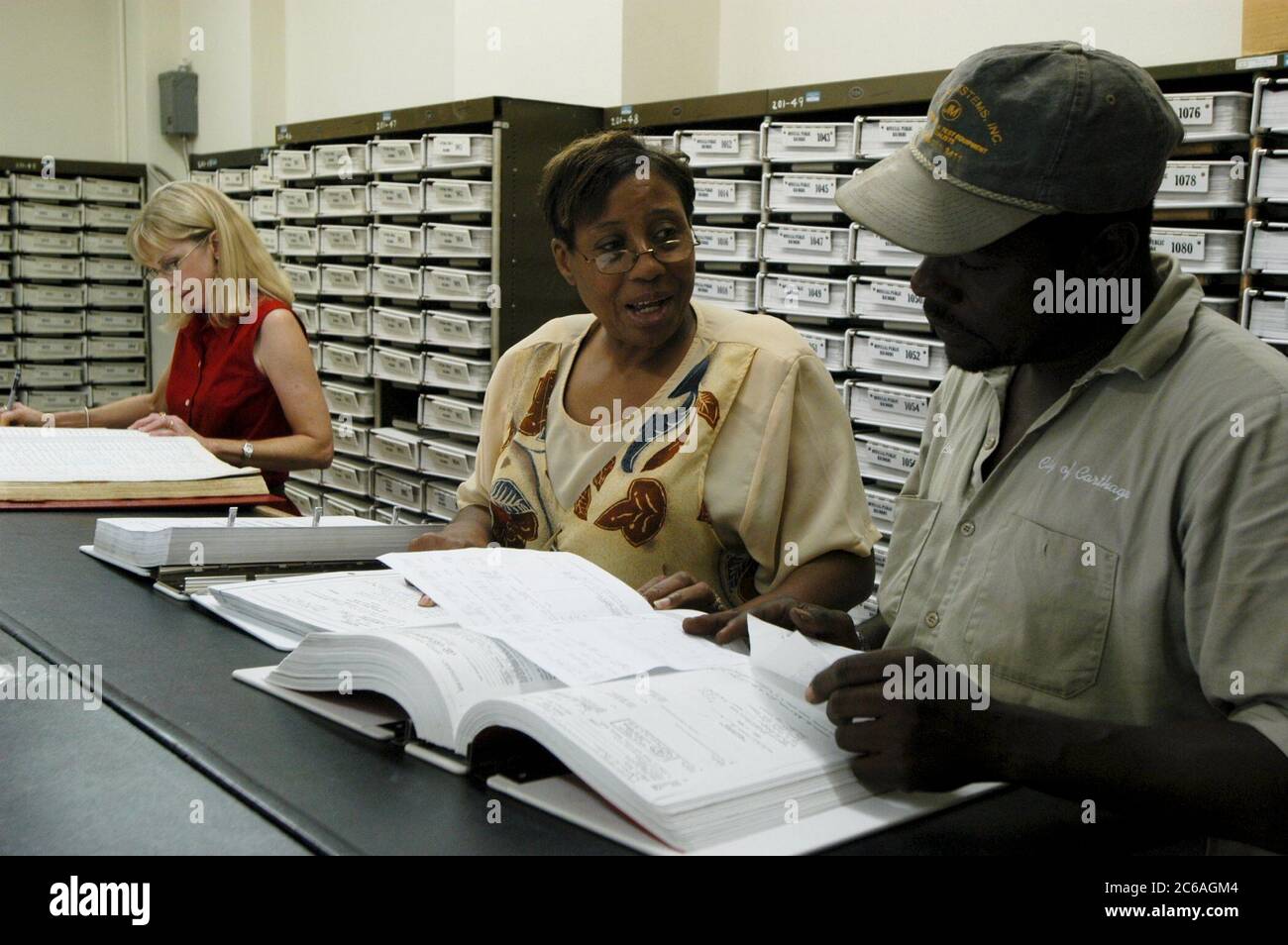 Carthage, Texas USA, luglio 2004.: Black man and woman research Land record registrati in volumi di carta presso il tribunale della contea di Panola. ©Bob Daemmrich Foto Stock