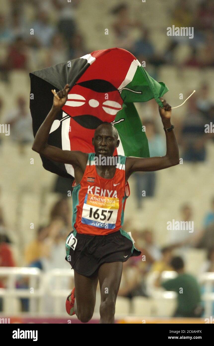 Atene, Grecia 23SEP04: Il Kenia Joseph Ngorialuk compie un giro di vittoria con la sua bandiera nazionale dopo aver vinto i 500 metri T13 per gli uomini in 15:21,25 alle Paralimpiadi. ©Bob Daemmrich Foto Stock