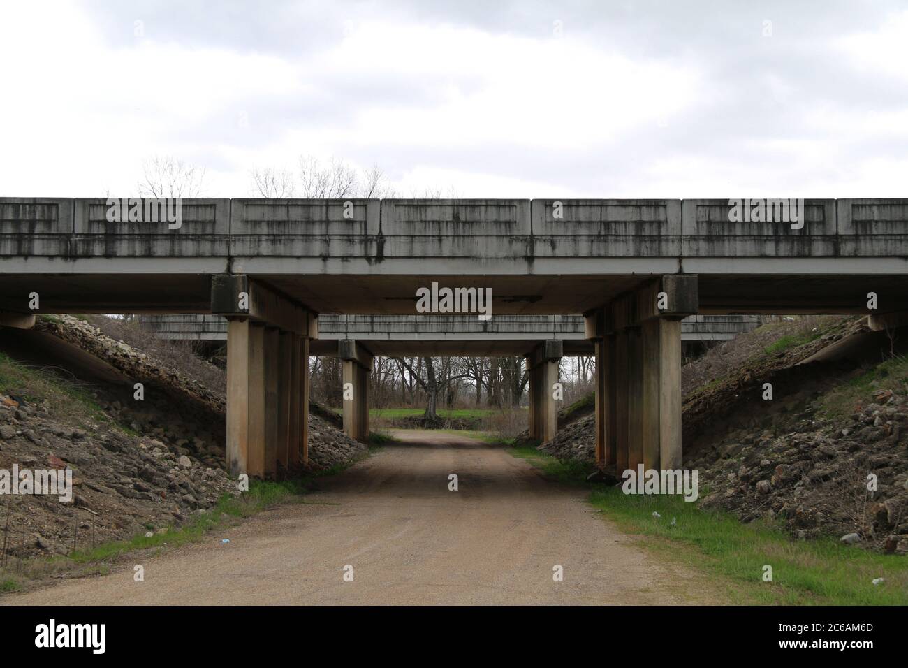 un ponte di cemento che attraversa un sentiero sterrato di campagna Foto Stock
