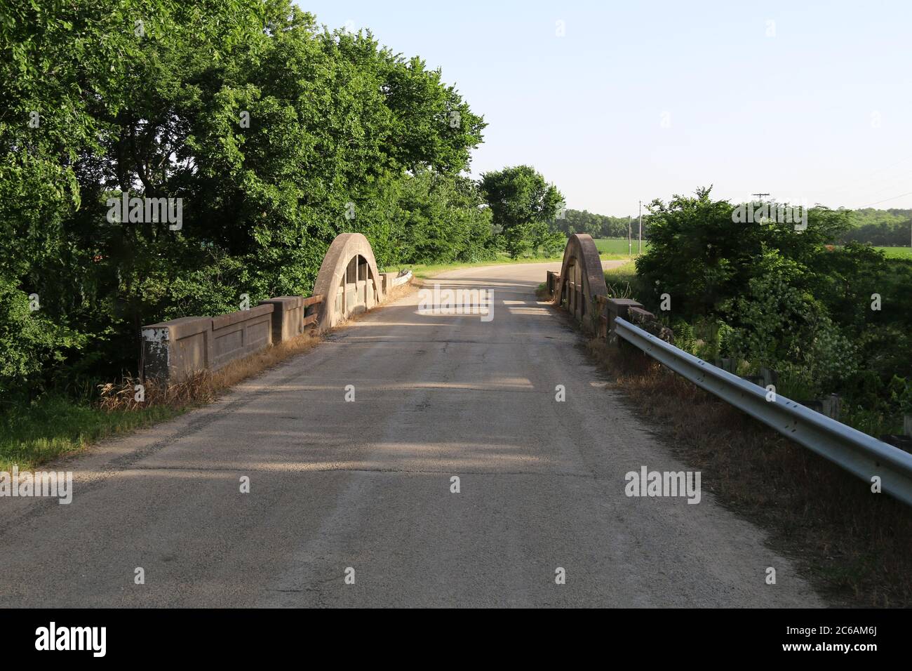 un ponte fluviale di campagna in campagna a un incrocio sterrato Foto Stock