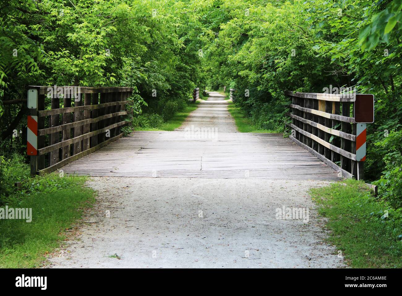 un sentiero sterrato su diversi ponti attraverso la lussureggiante campagna rurale Foto Stock