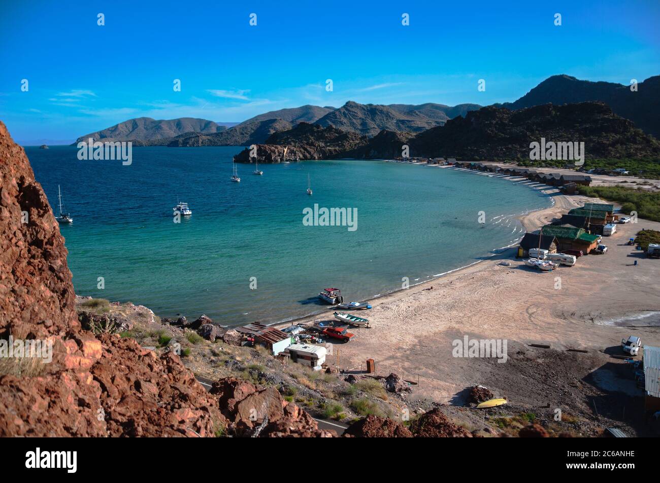 Guardando verso il basso su El Burro Cove a Baja California sur, Messico. Le barche a vela sono all'ancora e le palapas si trovano sulla spiaggia. Foto Stock