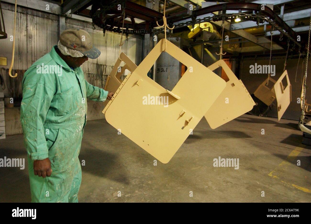 New Boston, Texas USA, 22 novembre 2004: Il lavoratore del Red River Army Depot ispeziona le porte dei veicoli mentre i meccanici si affrettano a riparare, rinnovare e riarmare gli Humvees militari diretti alla guerra in Iraq. I turni di meccanica sono attivi 24 ore su 24 presso la base militare di 33 000 acri nel nord-est del Texas. ©Bob Daemmrich Foto Stock