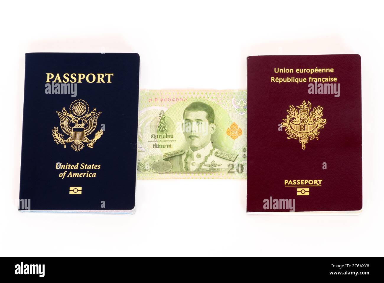Passaporti francesi e americani e valuta del baht thailandese. Concetto di concorrenza francese e americana per le imprese, il commercio e gli investimenti in Thailandia. Foto Stock