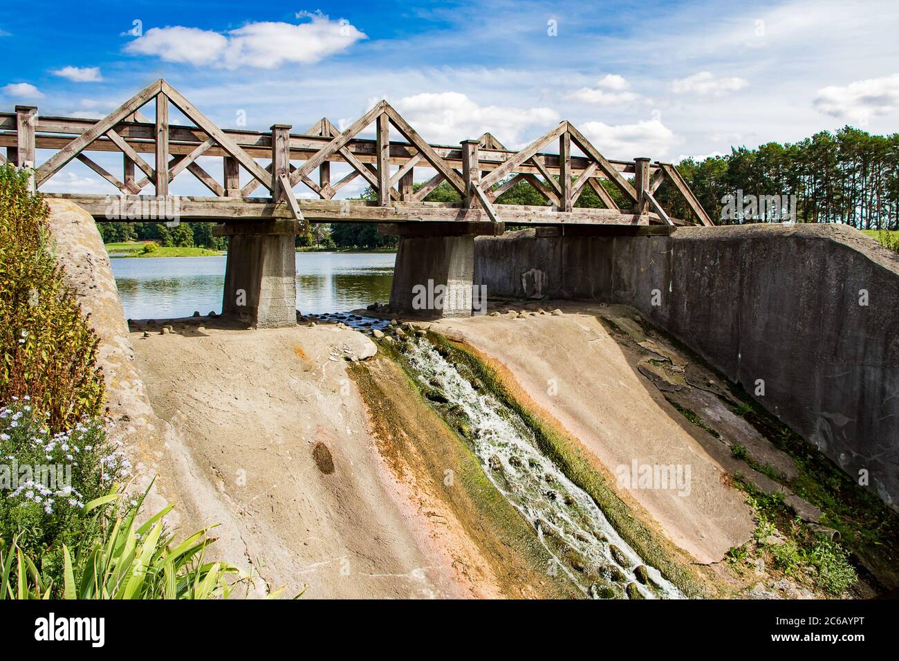 Vecchia diga con un ponte di legno. Vista sul paesaggio estivo soleggiato. Foto Stock