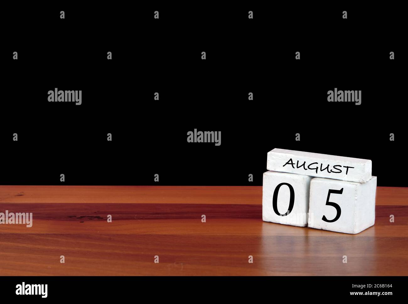 5 agosto mese di calendario. 5 giorni del mese. Calendario riflesso su pavimento in legno con sfondo nero Foto Stock