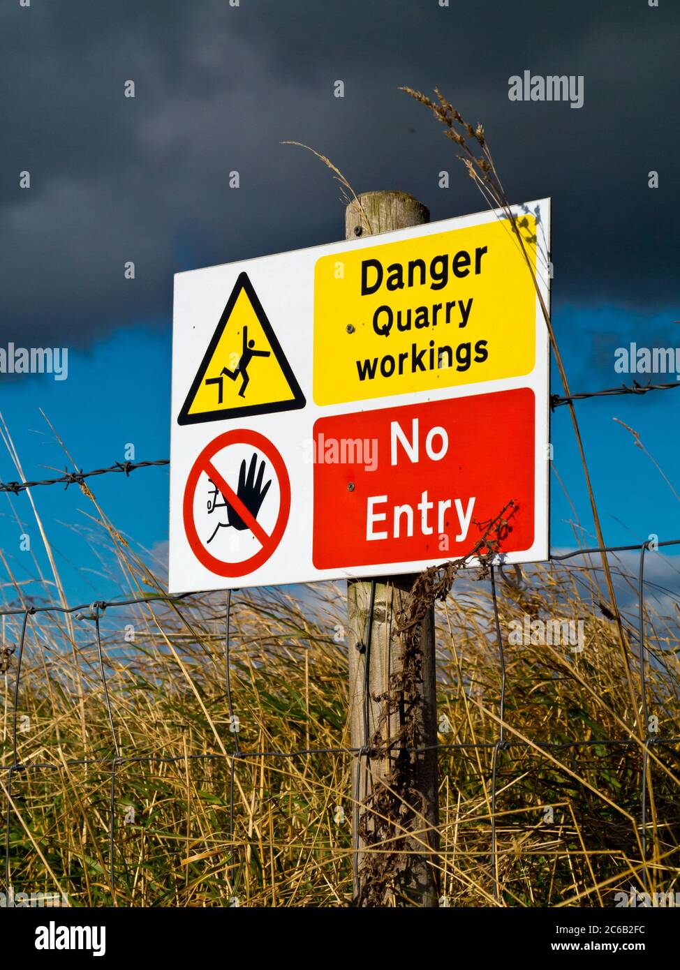 Pericolo lavori in cava Nessun cartello di pericolo di ingresso fuori da una cava con cielo tempestoso sopra. Foto Stock
