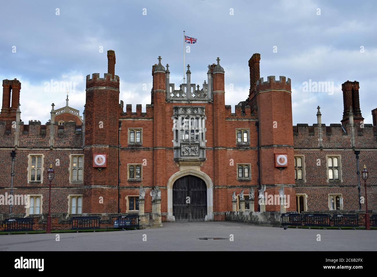 L'entrata principale all'Hampton Court Palace, Londra. Le grandi porte in legno sono chiuse e non ci sono visitatori. Tudor muratura e architettura. Foto Stock