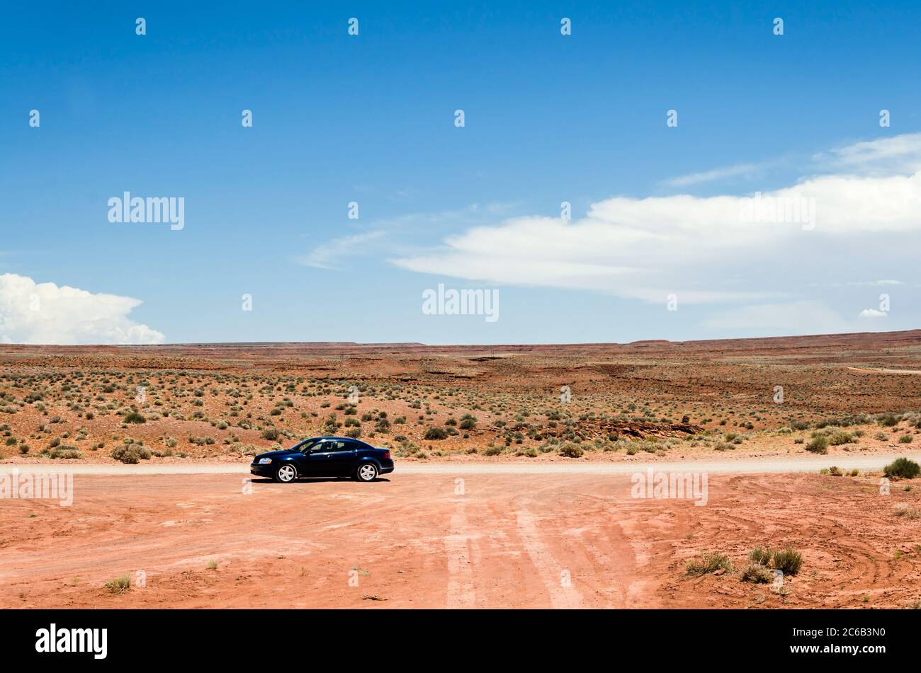 Auto su una strada sterrata in un paesaggio desertico panoramico Foto Stock