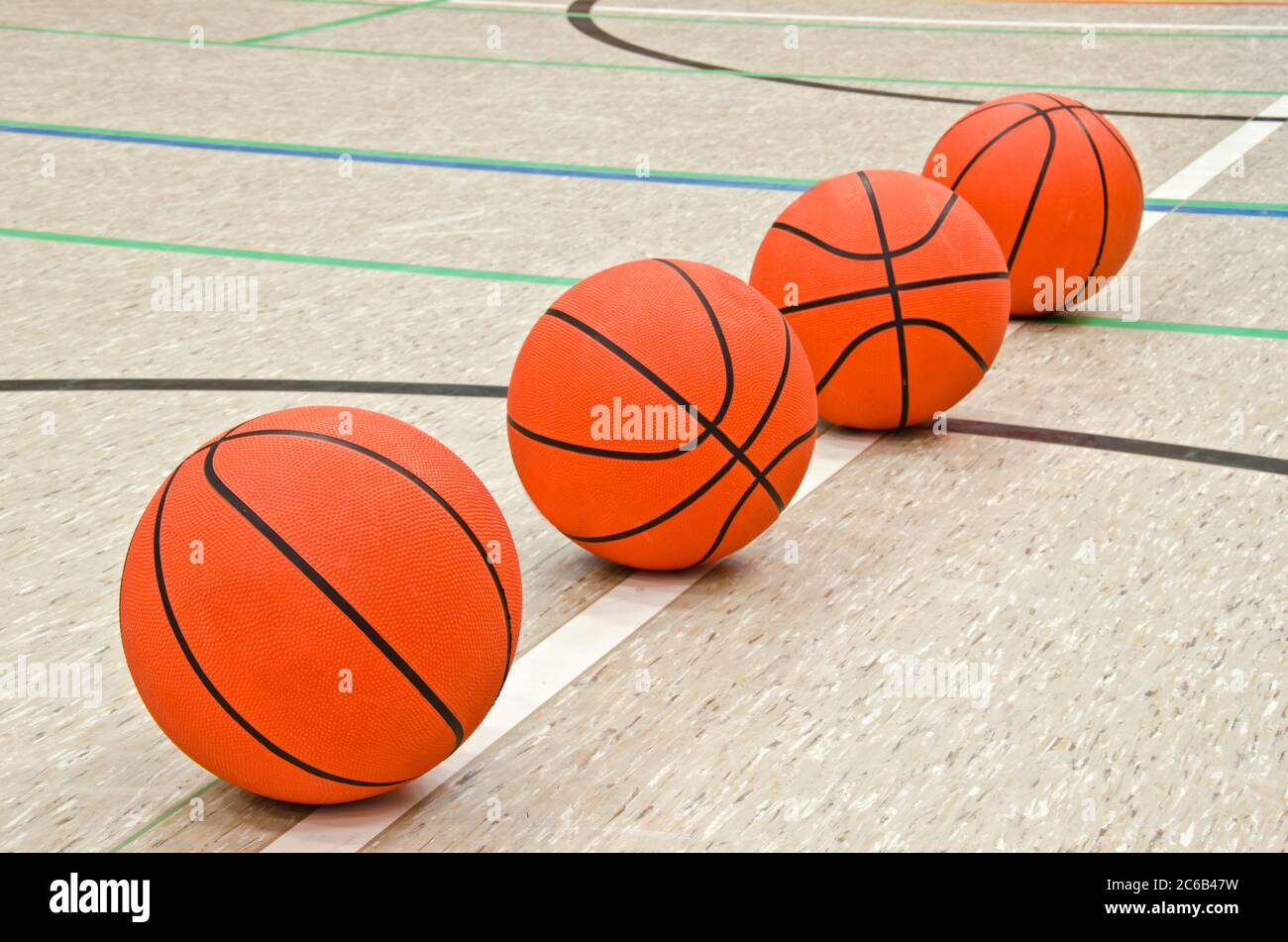 Palloni da basket sul pavimento nella sala sportiva Foto Stock