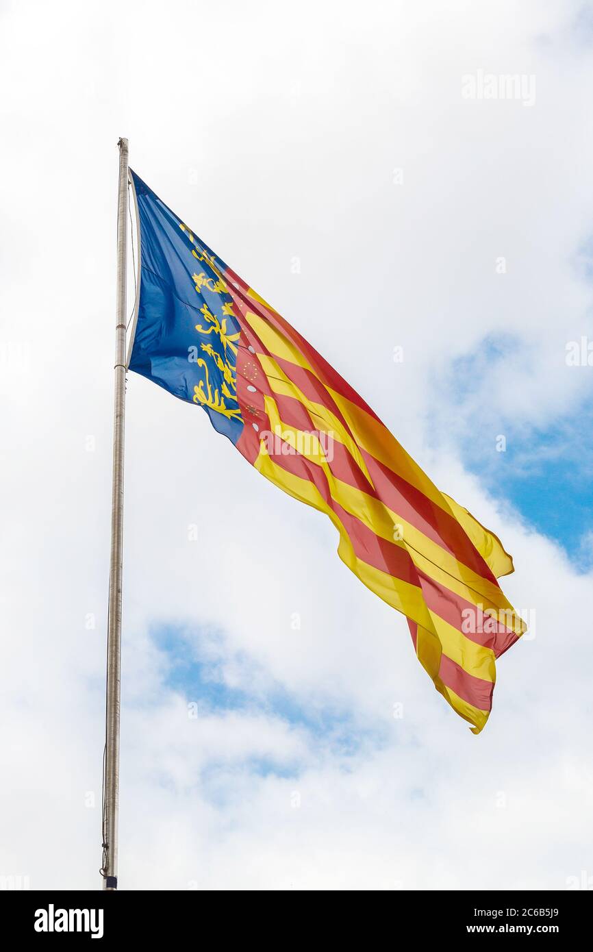 Bandiera di Valencia contro cielo nuvoloso, Spagna Foto Stock