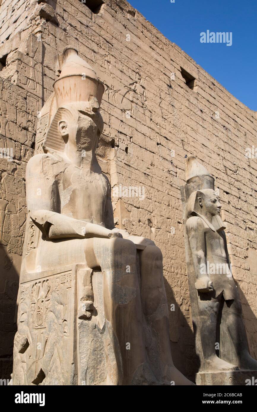 Colossi di Ramses II di fronte a Pylon, Tempio di Luxor, Sito Patrimonio dell'Umanità dell'UNESCO, Luxor, Tebe, Egitto, Africa del Nord, Africa Foto Stock