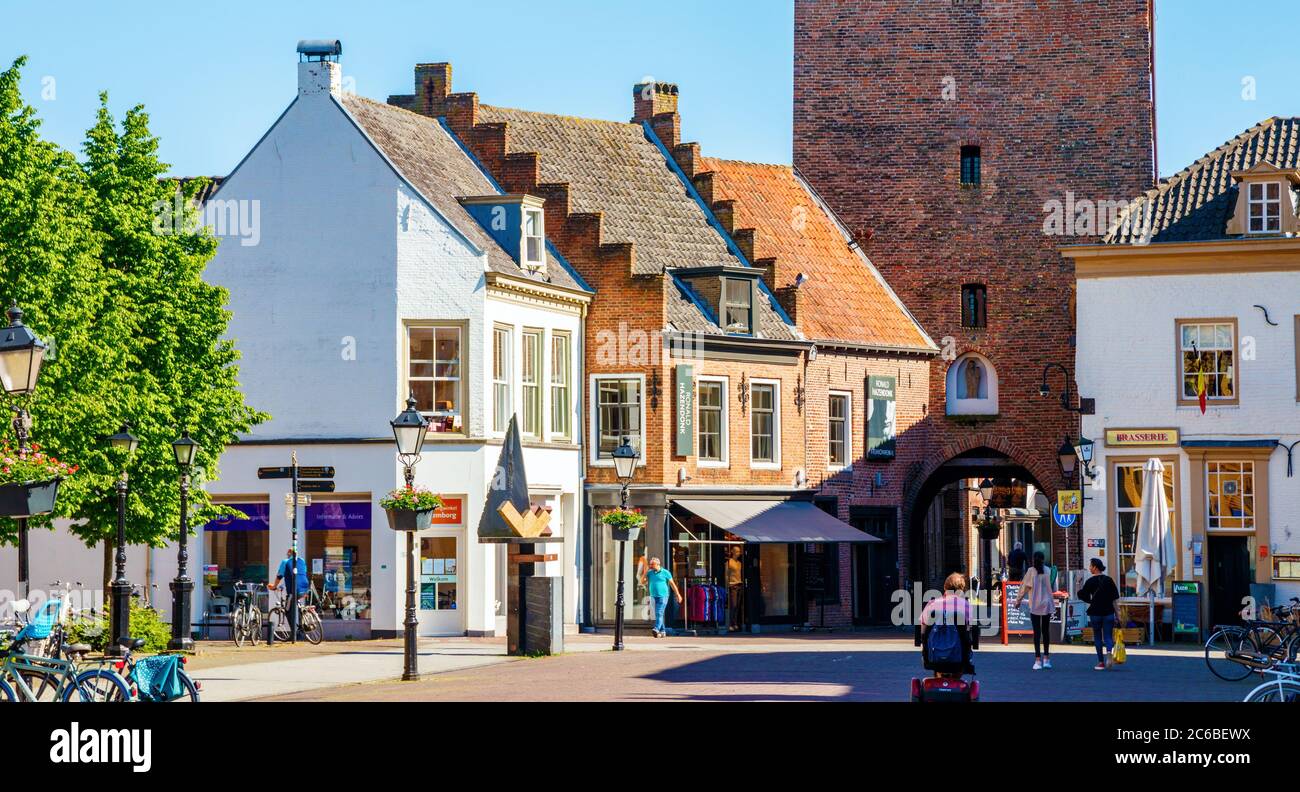 Vista sulla Piazza del mercato di Culemborg con negozi, vecchie case e la medievale Binnenpoort (porta della città) in un pomeriggio di sole. Gelderland, Paesi Bassi. Foto Stock