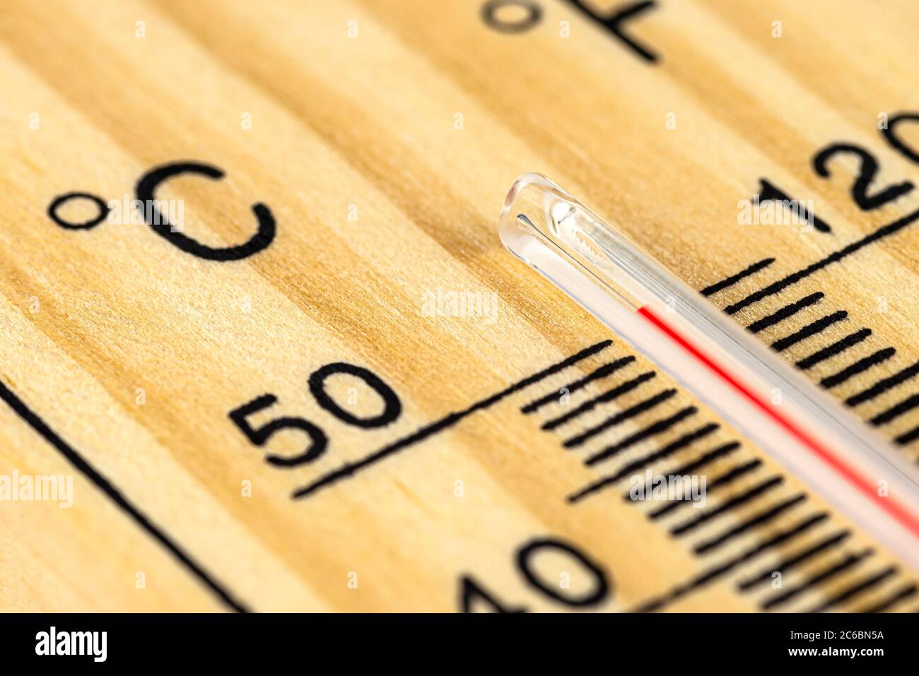 Un macro-shot di un classico termometro in legno che mostra una temperatura superiore a 50 gradi Celsius, 122 gradi Fahrenheit. Foto Stock