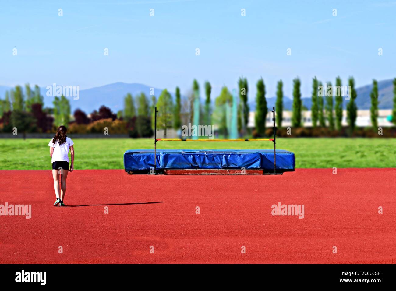 Atleta in preparazione al salto in alto sul tracciato atletico in Italia Foto Stock