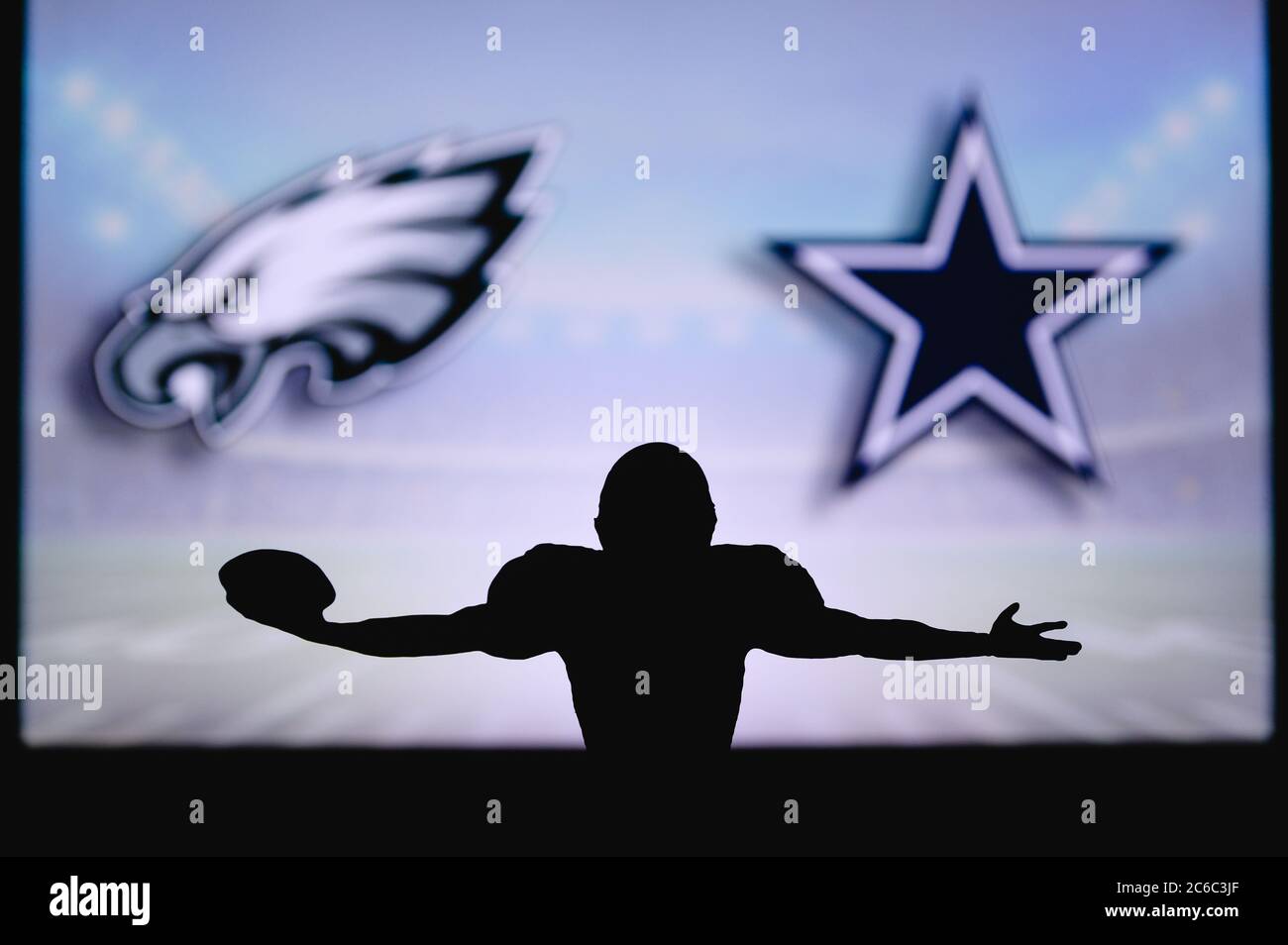 Philadelphia Eagles vs Dallas Cowboys. Gioco NFL. Partita della American Football League. Silhouette di giocatore professionista festeggia il tocco in giù. Schermata in ba Foto Stock