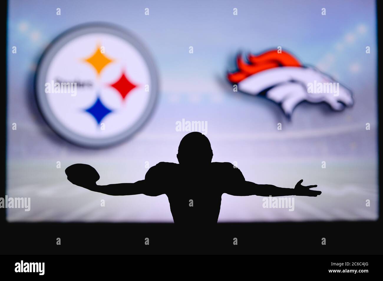 Pittsburgh Steelers vs. Denver Broncos. Gioco NFL. Partita della American Football League. Silhouette di giocatore professionista festeggia il tocco in giù. Schermata in ba Foto Stock