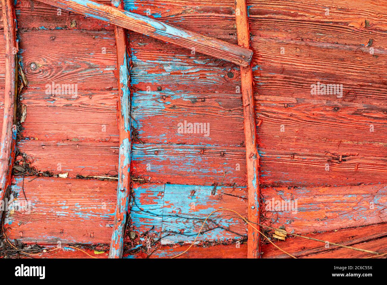 Strati di vernice rosso e blu all'interno di un vecchio battello a remi in legno Foto Stock